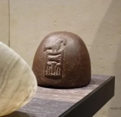 Quartzite weight, dating to the 31st century BCE, carries the name of Pharaoh Narmer within a serekh — the palace-facade design that served 